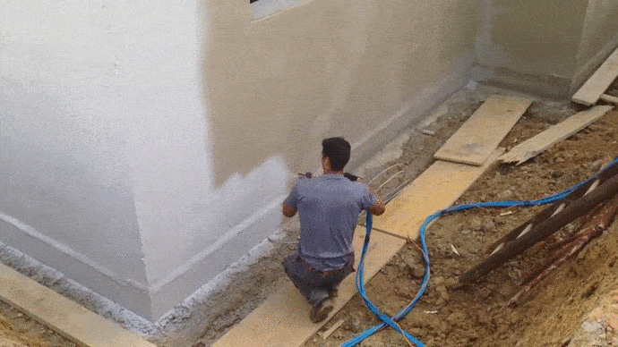Obrero utilizando maquina de proyectar pintura